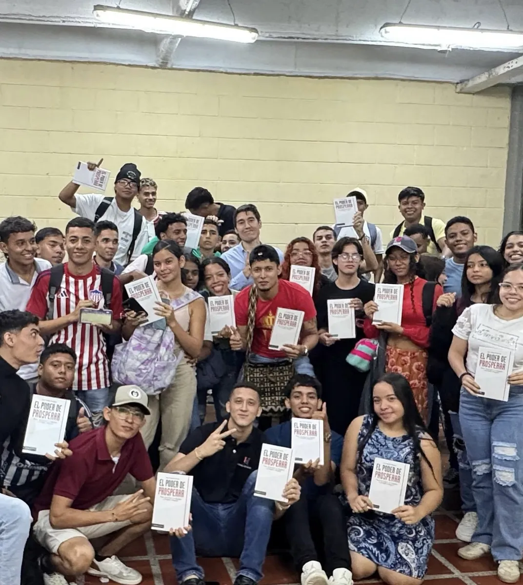 Grupo de jóvenes, cada uno con su ejemplar de El Poder de Prosperar, junto a Juan