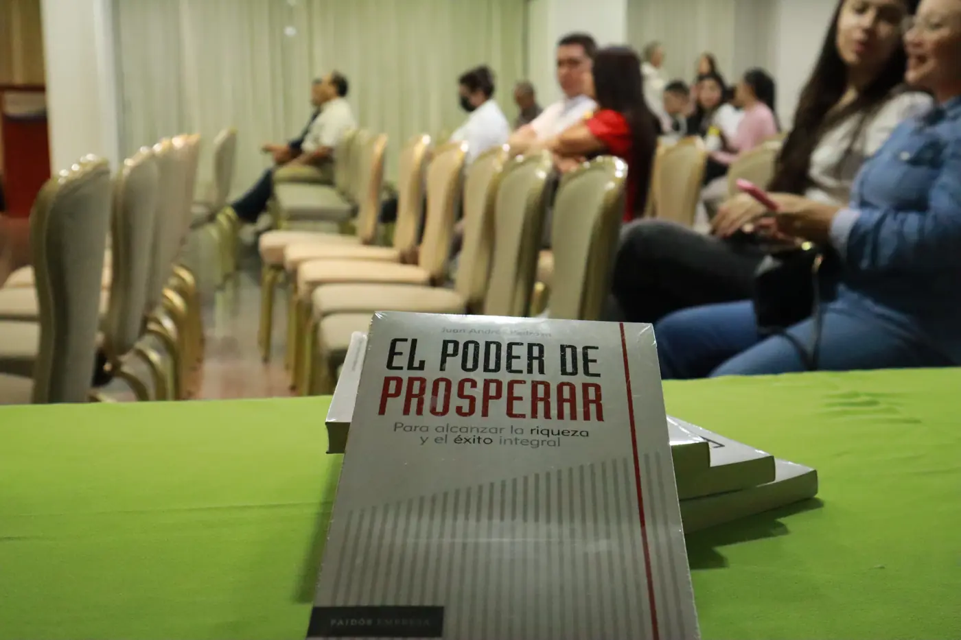 El Poder de Prosperar sobre la mesa frente al público